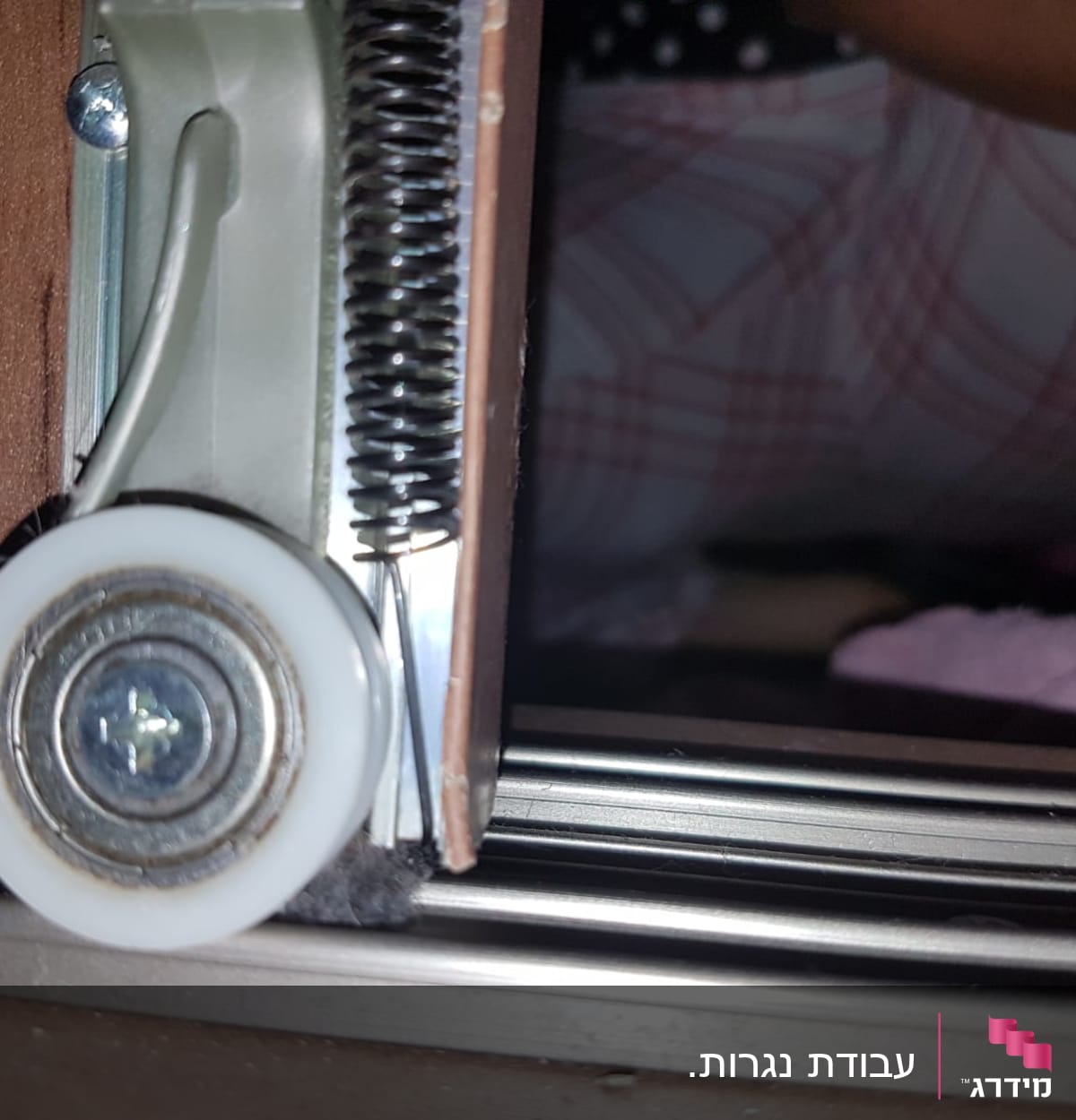 גלגלת פלסטיק עם קפיץ על מסילה מתכתית